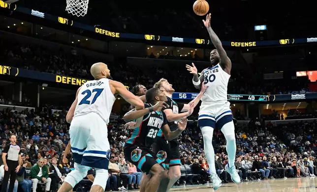 Minnesota Timberwolves forward Julius Randle (30) shoots over Memphis Grizzlies forward Cedric Coward (23), guard Cam Spencer, second from right, and forward GG Jackson II, fourth from right, as Timberwolves center Rudy Gobert (27) moves for position in the first half of an NBA basketball game Saturday, Jan. 31, 2026, in Memphis, Tenn. (AP Photo/Brandon Dill)