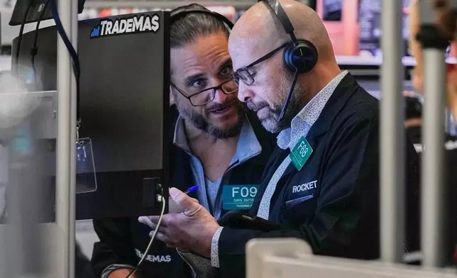 Options traders Chris Dattolo, left, and Steven Rodriguez work on the floor of the New York Stock Exchange, Friday, Feb. 20, 2026. (AP Photo/Richard Drew)