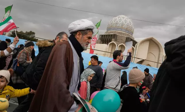 A cleric and other people attend an annual rally marking 1979 Islamic Revolution in Tehran, Iran, Wednesday, Feb. 11, 2026. (AP Photo/Vahid Salemi)