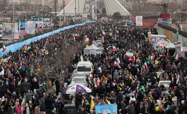 People attend an annual rally marking 1979 Islamic Revolution as the Azadi (Freedom) monument tower is seen at rear in Tehran, Iran, Wednesday, Feb. 11, 2026. (AP Photo/Vahid Salemi)
