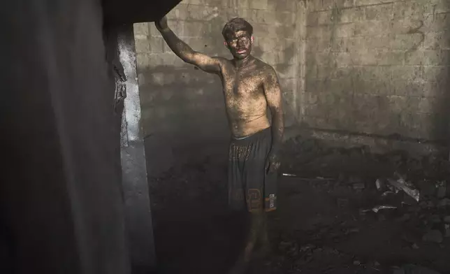 Diego Armando Custodio stands inside a coal sales market where he works in Buenos Aires, Argentina, Tuesday, Feb. 10, 2026. (AP Photo/Rodrigo Abd)