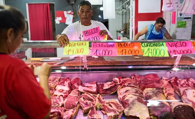 A butcher shop worker displays the prices of different cuts of meat in Buenos Aires, Argentina, Tuesday, Feb. 10, 2026. (AP Photo/Rodrigo Abd)