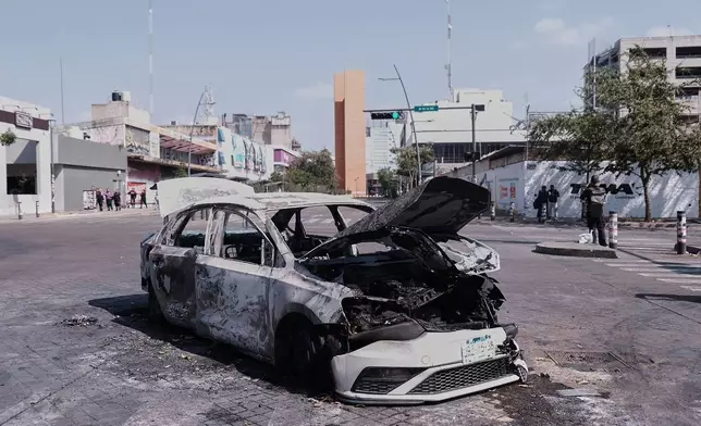 A vehicle sits charred after being set on fire, on a road in Guadalajara, Jalisco state, Mexico, Sunday, Feb. 22, 2026, after the death of the leader of the Jalisco New Generation Cartel, "El Mencho." (AP Photo/Alejandra Leyva)