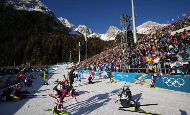 Athletes react in the finish area after the women's 10-kilometer pursuit biathlon race at the 2026 Winter Olympics in Anterselva, Italy, Sunday, Feb. 15, 2026. (AP Photo/Andrew Medichini)