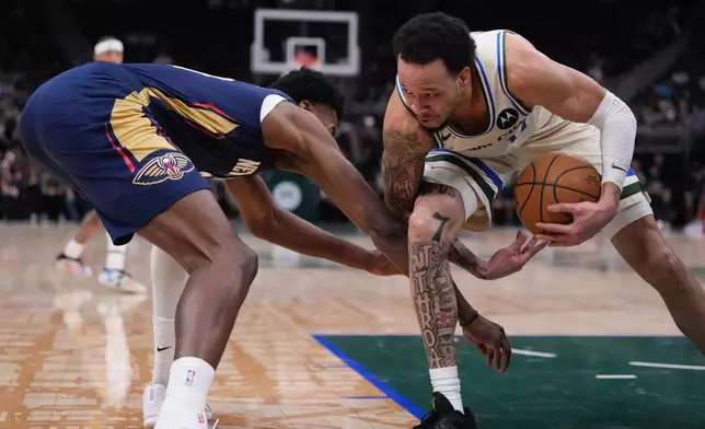 Milwaukee Bucks' Amir Coffey grabs a loose ball in front of New Orleans Pelicans' Yves Missi during the first half of an NBA basketball game Wednesday, Feb. 4, 2026, in Milwaukee. (AP Photo/Morry Gash)