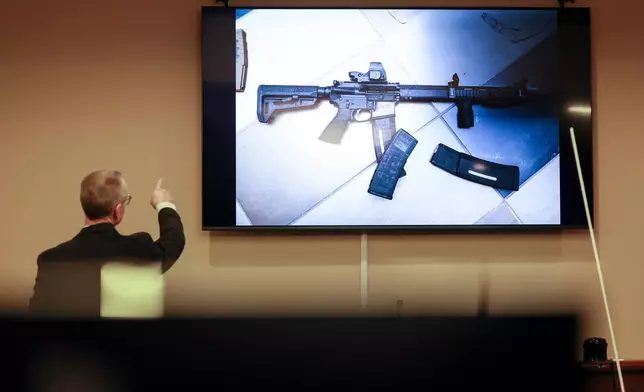 District Attorney Brad Smith, left, points to a weapon that was displayed on the screen during the first day of the trial of Colin Gray, the father of Apalachee High School shooting suspect Colt Gray, in the courtroom at the Barrow County courthouse, Monday, Feb. 16, 2026, in Winder, Ga. (Jason Getz/Atlanta Journal-Constitution via AP)