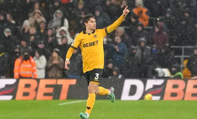 Wolverhampton Wanderers' Hugo Bueno celebrates with teammates after scoring his side the first goal during the Premier League soccer match between Wolverhampton Wanderers and Arsenal in Wolverhampton, England, Wednesday, Feb. 18, 2026. (AP Photo/Dave Shopland)