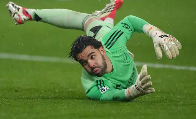 Arsenal's goalkeeper David Raya tries to block a shot during the Premier League soccer match between Wolverhampton Wanderers and Arsenal in Wolverhampton, England, Wednesday, Feb. 18, 2026. (AP Photo/Dave Shopland)