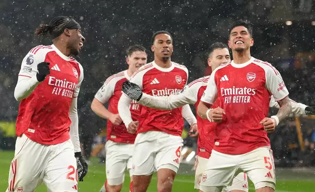Arsenal's Piero Hincapie, rights, celebrates with teammates after scoring his side the second goal during the Premier League soccer match between Wolverhampton Wanderers and Arsenal in Wolverhampton, England, Wednesday, Feb. 18, 2026. (AP Photo/Dave Shopland)