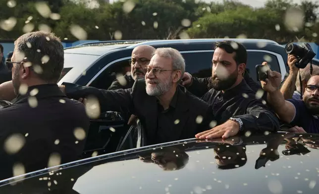 FILE - Ali Larijani, center, secretary of Iran's Supreme National Security Council, gestures as Hezbollah supporters throw rice to welcome him outside Rafik Hariri International Airport in Beirut, Lebanon, Wednesday, Aug. 13, 2025. (AP Photo/Bilal Hussein, File)