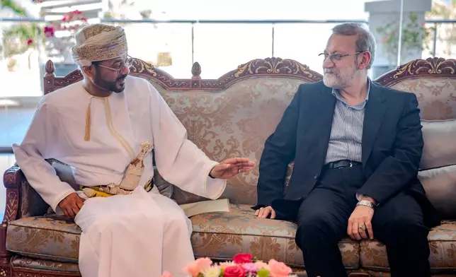 In this photo released by Iran's Supreme National Security Council office, Secretary of the Supreme National Security Council Ali Larijani, right, listens to Omani Foreign Minister Badr al-Busaidi during their meeting in Muscat, Oman, Tuesday, Feb. 10, 2026. (Erfan Kouchari/Iran's Supreme National Security Council Office via AP)