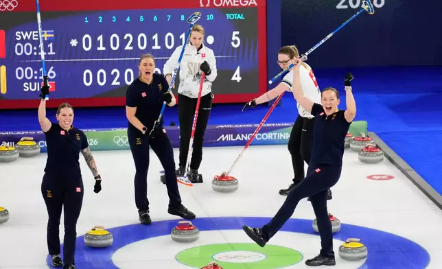 Sweden's Sara McManus, Agnes Knochenhauer and Sofia Scharback celebrate after beating Switzerland during a women's curling round robin match at the 2026 Winter Olympics, in Cortina d'Ampezzo, Italy, Monday, Feb. 16, 2026. (AP Photo/David J. Phillip)