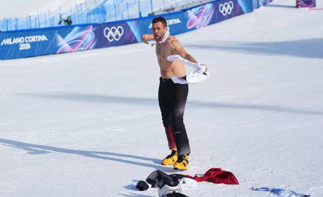 Austria's Benjamin Karl takes off his shirt as he celebrates winning the gold medal after the men's snowboarding parallel giant slalom finals at the 2026 Winter Olympics, in Livigno, Italy, Sunday, Feb. 8, 2026. (AP Photo/Lindsey Wasson)