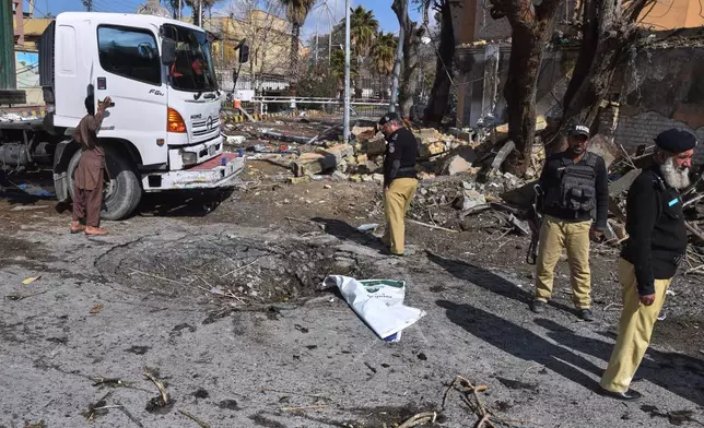 Police officers examine the site of Saturday's suicide bombing, in Quetta, Pakistan, Sunday, Feb. 1, 2026. (AP Photo/Arshad Butt)