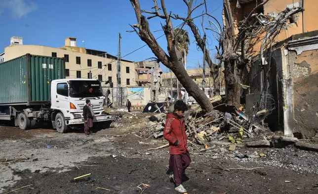 People walk past the site of Saturday's suicide bombing, in Quetta, Pakistan, Sunday, Feb. 1, 2026. (AP Photo/Arshad Butt)