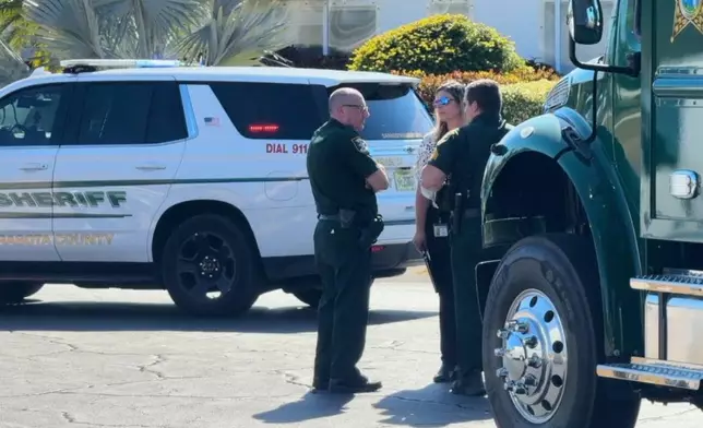 In this image taken from video provided by WFTS, law enforcement officers investigate a scene, Wednesday, Feb. 11, 2026, in Sarasota, Fla., which authorities say is connected to another crime scene, in Fort Lauderdale, Fla. (WFTS via AP)