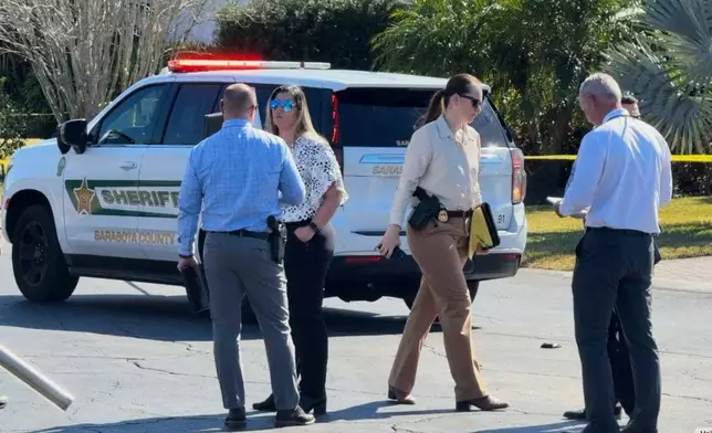 In this image from video provided by WFTS, law enforcement officers investigate a scene, Wednesday, Feb. 11, 2026, in Sarasota, Fla., which authorities say is connected to another crime scene, in Fort Lauderdale, Fla. (WFTS via AP)