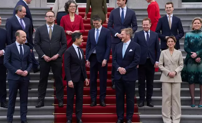 Ministers of the new three-party minority government pose with King Willem-Alexander, center right, prime minster Rob Jetten, center left, and deputy prime minister Dilan Yesilgöz, front row right, on the steps of Royal Palace Huis ten Bosch in The Hague, Netherlands, Monday, Feb. 23, 2026. (AP Photo/Peter Dejong)