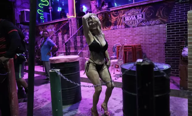 A sex worker dances during a pre-Carnival street party in the Vila Mimosa red-light district in Rio de Janeiro, Brazil, Friday, Feb. 6, 2026. (AP Photo/Silvia Izquierdo)