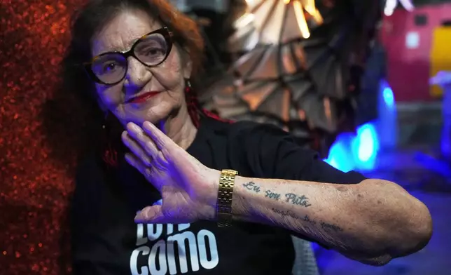 Former sex worker Lourdes Barreto shows a tattoo that reads in Portuguese, "I am a whore," at the Porta da Pedra samba school in Rio de Janeiro, Monday, Feb. 9, 2026. (AP Photo/Silvia Izquierdo)