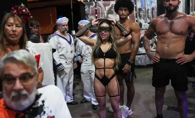 Pole dancer Sara Santos, center, prepares for a media presentation at the Porto da Pedra samba school in Sao Goncalo, Rio de Janeiro state, Monday, Feb. 9, 2026. (AP Photo/Silvia Izquierdo)