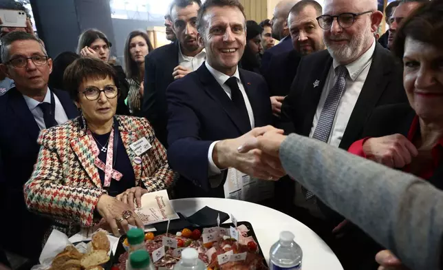 French President Emmanuel Macron, center, with Christiane Lambert, left, at the International Agriculture Fair during the opening day in Paris, Saturday, Feb. 21, 2026. (Christophe Petit Tesson/Pool Photo via AP)