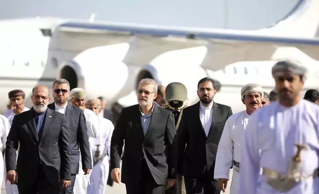 In this photo released by Iran's Supreme National Security Council office, Secretary of the Supreme National Security Council Ali Larijani, center, arrives in Muscat, Oman, Tuesday, Feb. 10, 2026. (Erfan Kouchari/Iran's Supreme National Security Council Office via AP)