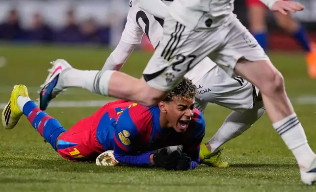 Barcelona's Lamine Yamal falls next to Albacete's Dani Bernabeu during a Copa del Rey quarterfinal soccer match between Albacete and Barcelona, in Albacete, Spain, Tuesday, Feb. 3, 2026. (AP Photo/Manu Fernandez)