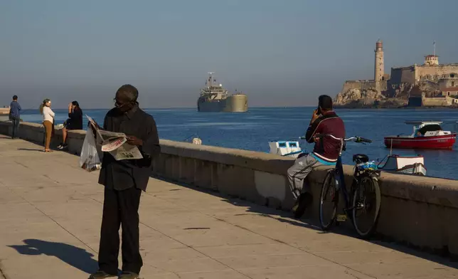 A man reads a newspaper at the Havana Bay where the Mexican Navy ship Isla Holbox arrives in Cuba, Thursday, Feb. 12, 2026. (AP Photo/Ramon Espinosa)