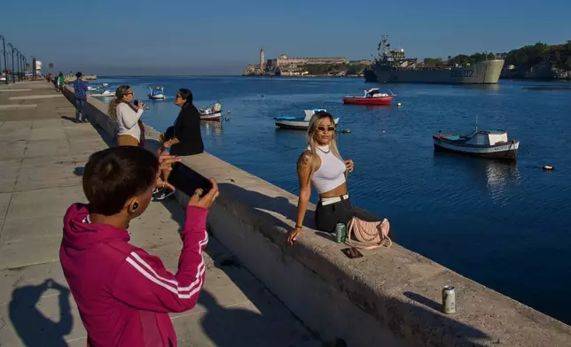 People take photos at Havana Bay as the Mexican Navy ship Isla Holbox arrives in Cuba, Thursday, Feb. 12, 2026. (AP Photo/Ramon Espinosa)
