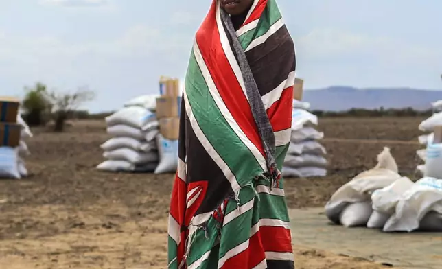 FILE - A child stands in front of food aid supplied by the World Food Programme (WFP) ahead of distribution in Nalemkais Village, Turkana County, Kenya, Feb. 8, 2026. (AP Photo/Patrick Ngugi, File)