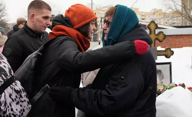 A woman greets late Russian opposition leader Alexei Navalny's mother Lyudmila Navalnaya, right, at his grave, two years after his death, at the Borisovskoye Cemetery in Moscow, on Monday, Feb. 16, 2026. (AP Photo/Alexander Zemlianichenko)