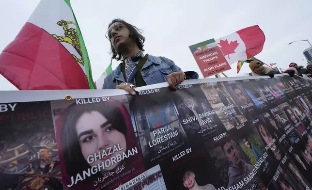 Supporters of Iran's exiled Crown Prince Reza Pahlavi carry a banner presenting the people were killed in Iran during recent uprising, while attending a demonstration in Toronto, Saturday, Feb. 14, 2026. (AP Photo/Kamran Jebreili)