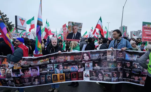 Supporters of Iran's exiled Crown Prince Reza Pahlavi carry a banner presenting the people were killed in Iran during recent uprising, while attending a demonstration in Toronto, Saturday, Feb. 14, 2026. (AP Photo/Kamran Jebreili)