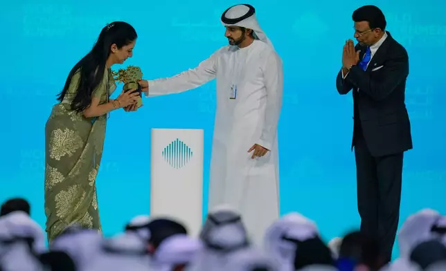Indian teacher Rouble Nagi, left, receives the Global Teacher Prize trophy from Dubai Crown Prince Sheikh Hamdan bin Mohammed Al Maktoum, as Varkey foundation founder Sunny Varkey, right, applauds during the ceremony, in Dubai, United Arab Emirates, Thursday, Feb. 5, 2026. (AP Photo/Altaf Qadri)