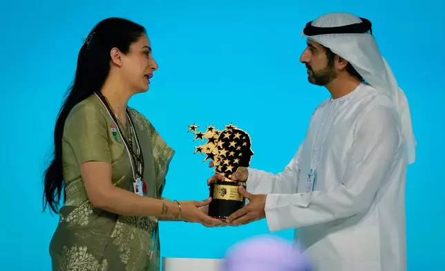 Indian teacher Rouble Nagi, left, receives the Global Teacher Prize trophy from Dubai Crown Prince Sheikh Hamdan bin Mohammed Al Maktoum, at a ceremony in Dubai, United Arab Emirates, Thursday, Feb. 5, 2026. (AP Photo/Altaf Qadri)
