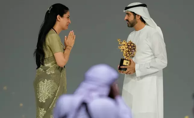 Indian teacher Rouble Nagi, left, greets Dubai Crown Prince Sheikh Hamdan bin Mohammed Al Maktoum before receiving the Global Teacher Prize trophy from him at a ceremony awarding the Global Teacher Prize in Dubai, United Arab Emirates, Thursday, Feb. 5, 2026. (AP Photo/Altaf Qadri)