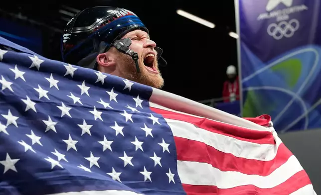 United States' Austin Florian reacts as he arrives at the finish during a men's skeleton run at the 2026 Winter Olympics, in Cortina d'Ampezzo, Italy, Friday, Feb. 13, 2026. (AP Photo/Alessandra Tarantino)