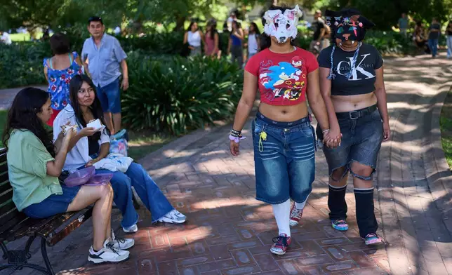 Youths walk through a park during a gathering of therians, people who say they identify as non-human animals, in Buenos Aires, Argentina, Sunday, Feb. 22, 2026. (AP Photo/Rodrigo Abd)