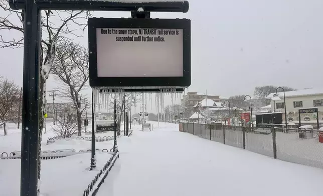 A sign indicates NJ Transit train service suspension due to snow storm conditions in Rutherford, N.J., Monday, Feb. 23, 2026. (AP Photo/Ted Shaffrey)