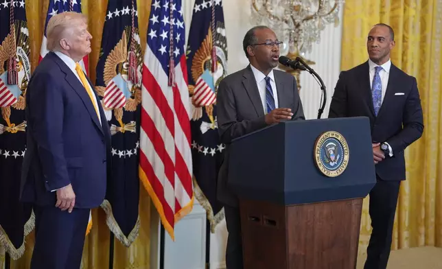 President Donald Trump and Housing and Urban Development Secretary Scott Turner, right, listen as former Housing and Urban Development Secretary Dr. Ben Carson speaks during a Black History Month event in the East Room of the White House, Wednesday, Feb. 18, 2026, in Washington. (AP Photo/Evan Vucci)