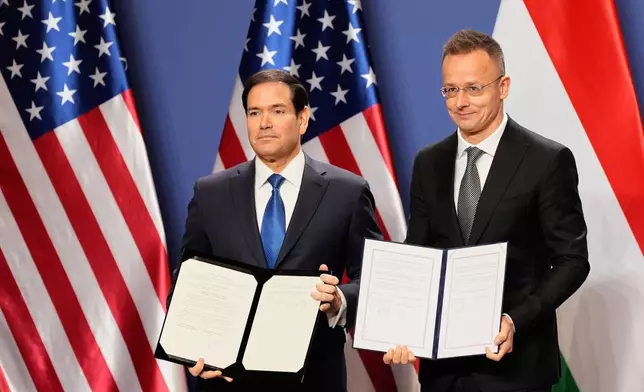 U.S. Secretary of State Marco Rubio, left, and Hungary's Foreign Minister Peter Szijjarto pose with documents after signing the U.S-Hungary Intergovernmental Agreement on Civil Nuclear Cooperation in Budapest, Hungary, Monday, Feb. 16, 2026. (AP Photo/Alex Brandon, Pool)