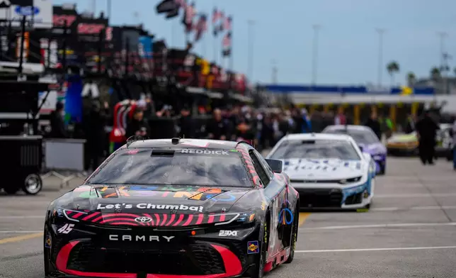 Driver Tyler Reddick leads other cars out to the track during a NASCAR Daytona 500 practice, Wednesday, Feb. 11, 2026, in Daytona, Fla. (AP Photo/Mike Stewart)