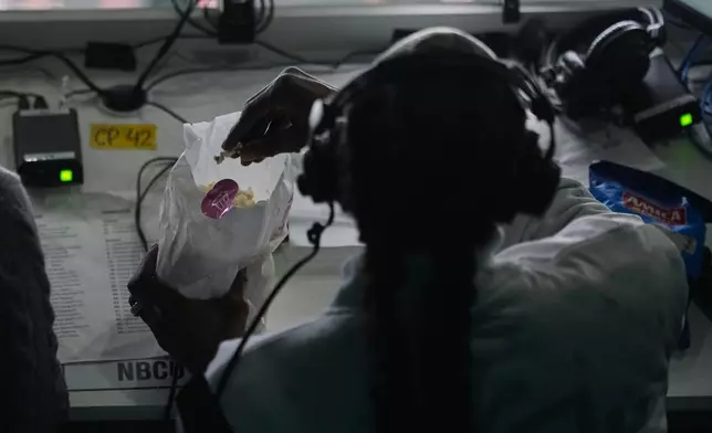 Snoop Dogg eats popcorn during the men's ice hockey quarterfinal game between the United States and Sweden at the 2026 Winter Olympics, in Milan, Italy, Wednesday, Feb. 18, 2026. (AP Photo/Carolyn Kaster)