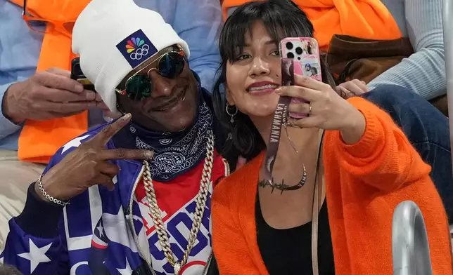 Snoop Dogg poses for a selfie as he watches the women's 500 meters speedskating race at the 2026 Winter Olympics, in Milan, Italy, Sunday, Feb. 15, 2026. (AP Photo/Antonio Calanni)