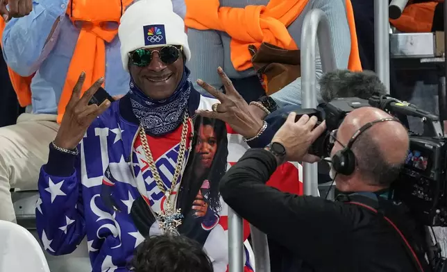 Snoop Dogg gestures as he watches the women's 500 meters speedskating race at the 2026 Winter Olympics, in Milan, Italy, Sunday, Feb. 15, 2026. (AP Photo/Antonio Calanni)
