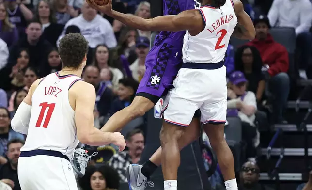 Los Angeles Clippers forward Kawhi Leonard (2) attempts to shoot around Sacramento Kings center Dylan Cardwell, center, during the first half of an NBA basketball game Friday, Feb. 6, 2026, in Sacramento, Calif. (AP Photo/Sara Nevis)