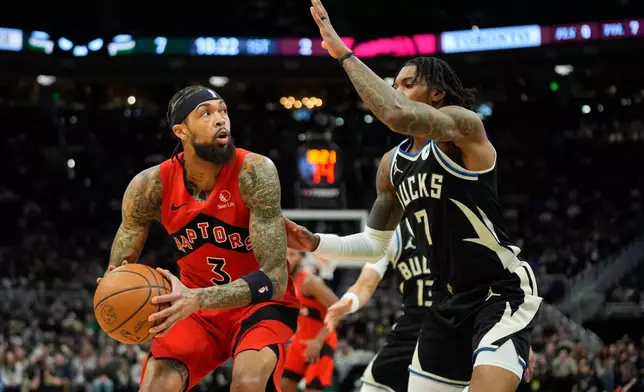 Toronto Raptors' Brandon Ingram looks to shoot against Milwaukee Bucks' Kevin Porter Jr. during the first half of an NBA basketball game Sunday, Feb. 22, 2026, in Milwaukee. (AP Photo/Aaron Gash)