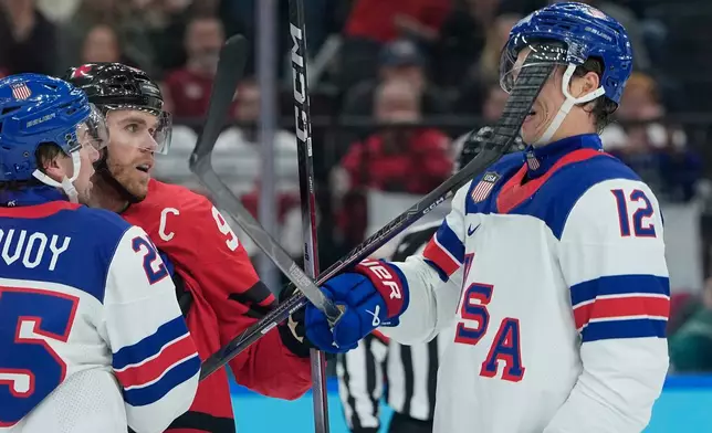 United States' Matt Boldy (12) is hit in the face by the stick of Canada's Connor McDavid (97) during the first period of a men's ice hockey gold medal game between Canada and the United States at the 2026 Winter Olympics, in Milan, Italy, Sunday, Feb. 22, 2026. (AP Photo/Petr David Josek)