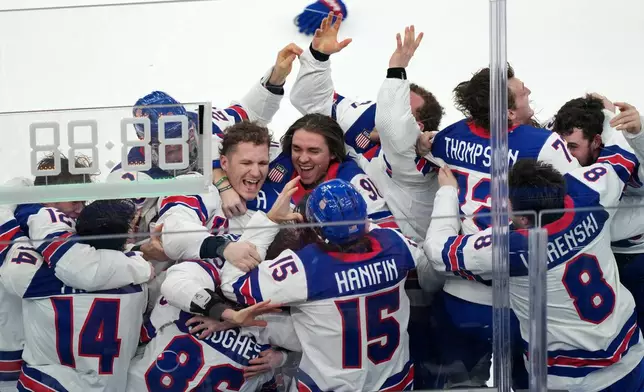 United States players celebrate after defeating Canada 2-1 in overtime to win the men's ice hockey gold medal game at the 2026 Winter Olympics in Milan, Italy, Sunday, Feb. 22, 2026. (AP Photo/Carolyn Kaster)